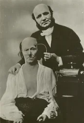 French neurologist Duchenne de Boulogne using his electrophysiology apparatus on an old man