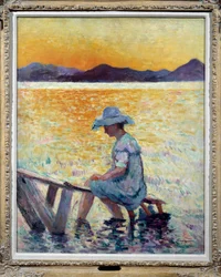 Saint Tropez, sunset A woman sitting her feet in the water on the shore