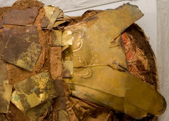 A golden mask with a monkey image revealed
