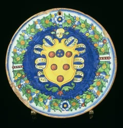 Maiolica plate bearing the Medici coat of arms with a border of foliage and fruit, Italian, 16th century