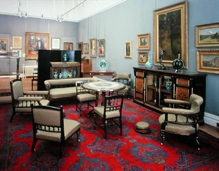 Suite comprising a cabinet, centre table, sofa, pair of side chairs, pair of armchairs, nursing chair, armchair and card table, 1880s