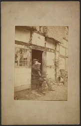 Seated man drinking from mug in open doorway