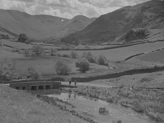 A View Looking Across a Bridge, Stream, Fields and Fells