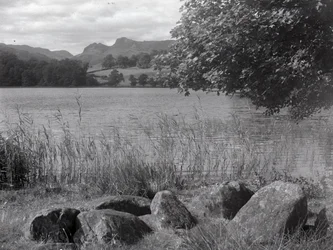 View across Loughrigg Tarn with stones in the foreground