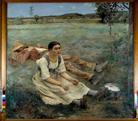 A woman sitting in the grass next to a man sleeping during the harvest season