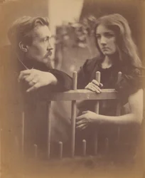 [Young man and woman leaning on a picket fence]