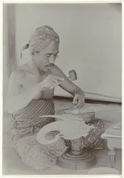 Javanese Man Creating a Human-Like Figure with Hammer and Instruments