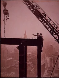 Empire State Building under construction, showing placing of steel girder