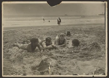 Children Laying in Sand at Beach
