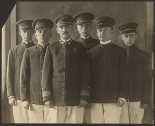 Group of Young Men in Uniform Before Tapestry
