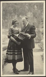 [Man and Woman Standing Outside with Magazine]