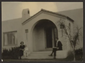 [Woman and Man in front of a House]