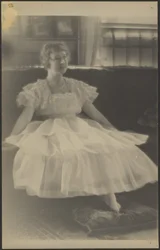 [Woman in Chiffon Dress Seated on Sofa]