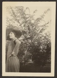 Woman in Hat Standing in Orchard