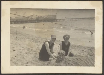 [Women on the Beach Burying Friend in Sand]