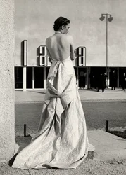 Model seen from the back wears an evening dress created by the couture house "Lamma"