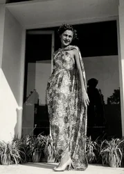 Model wears a long dress with a floral pattern created by the couture house 