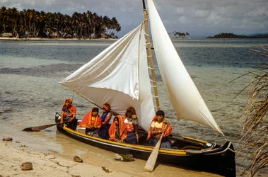 Women with gold nose rings of Cuna tribe of Mulatas aka San Blas Islands paddle and sail