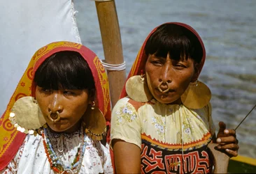 Women with gold nose rings of Cuna tribe of Mulatas aka San Blas Islands paddle and sail