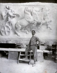 Full-Length Portrait of the Famous Sculptor Pietro Canonica. He is Posing in His Studio Before a Marble High Relief He is Working On (b/w photo)