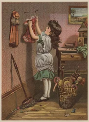 Girl hanging up dolls clothes