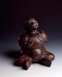 Pre-Columbian Art, Mayan Civilization, Initial Period: Anthropomorphic Clay Vase Depicting a Man Sitting with His Hands on His Chest Wearing a Monkey Mask with His Mouth Open. From Uaxactun, Guatemala. Guatemala, Museo Nazionale di Archeologia
