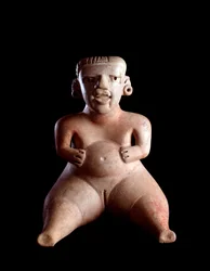 Pre-Columbian Art, Mayan Civilization, Pre-Classical Period: Clay Statuette Depicting a Seated Woman, Belly Swollen and Legs Apart (Parturiente?). From Kaminaljuyu, Guatemala. Guatemala, Museo Nazionale di Archeologia e Etnologia