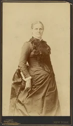 [Unidentified woman in long dress standing]