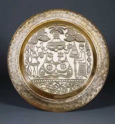 An Efik Brass Charger Embossed with a Central Robed Female Figure and Two Servants Holding a Fan and an Umbrella