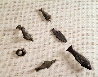 Christian antiquity: fibulae and metal jewelry in the shape of fish. National Museum of Archeology, Saint Germain en Laye
