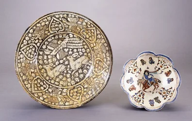 A Sultanabad pottery dish, depicting two seated deer amongst dense leafy motifs