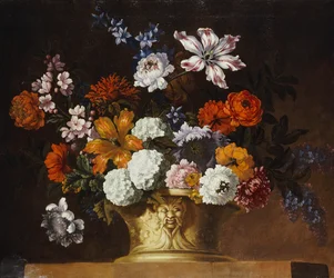 Tulips, snowballs and other flowers in a sculpted urn on a ledge