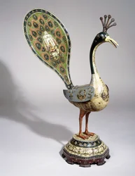 A Qajar peacock painted with flower designs, and pictorial cartouches depicting courtiers