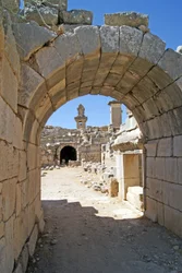 View through the vaulted entrance of the Xanthos theatre into the Orchestra pit, showing pillar and Harpy tomb, Xanthos, Turkey
