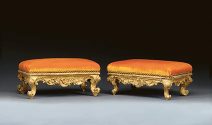 A matched pair of Italian rococo giltwood footstools