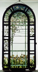 A leaded glass trellised window depicting clematis vines, early 20th century
