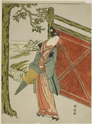 Young Man Holding Umbrella Beside a Fence
