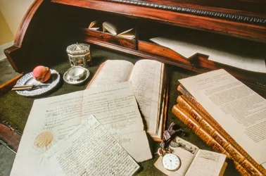 Documents, a watch, and other effects of George Washington are displayed on a desk