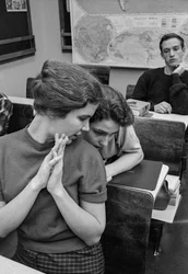 Female students socialize and chat in classroom at James A. Garfield High School