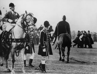 A suffragette attempts to attack the king as he arrives to open parliament, 1908