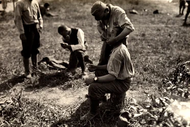 Austrian prisoners during World War I in Bagnaria Arsa, Udine, Italy; in the foreground a soldier shaves a fellow soldier, 02/04/1916