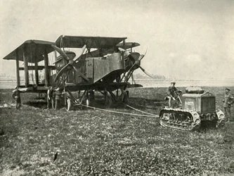 A Small Motor Tractor Getting a Huge R.A.F. Bombing Machine into Position