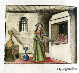 Alchemy 16th Century: An Alchemist at Work, Operating a Bellows in Front of His Workshop Fireplace, with a Stove and Alembic Behind Him
