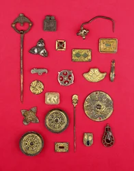 Collection of Anglo-Saxon and Celtic jewellery including gilt bronze mounts, saucer and cruciform brooches and a Merovingian pendant