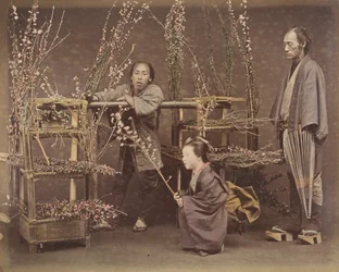 Two Japanese Men and One Japanese Woman Posing with Flowering Branches, 1870s