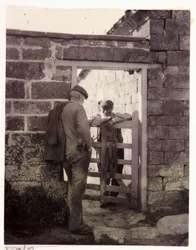Two men talking over a gate, c 1905