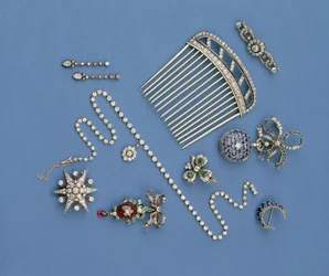 Selection of diamond jewellery: hair comb; graduated collet necklace; sapphire crescent brooch; enamel carbuncle pendant; fob watch; star brooch