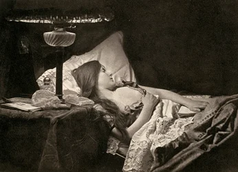 A young woman sleeping on candid embroidered sheets in a bed