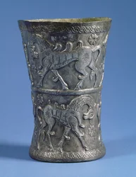 Marlik beaker of waisted cylindrical form with two decorative bands depicting parade horses, c.1100 BC