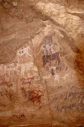 Rock art, Prehistory: Rock painting of a group of cattle and characters in an ornate shelter, in the Uweinat massif, Sudan